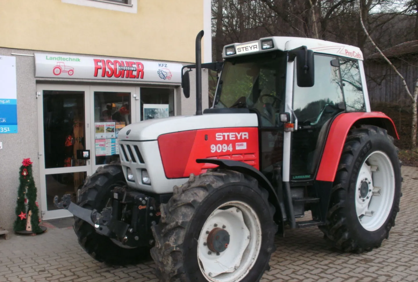 Ein Traktor vor dem Geschäft von Fischer Landtechnik und Kfz